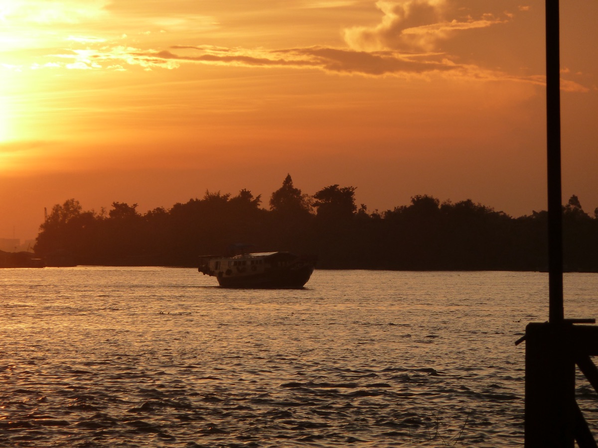 Een boot bij zonsondergang op de rivier bij Vinh Long