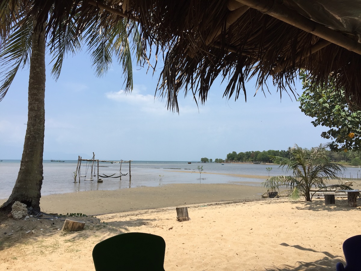 Een strandtent met rieten dak aan een ondiepe zee bij eb op Phu Quoc