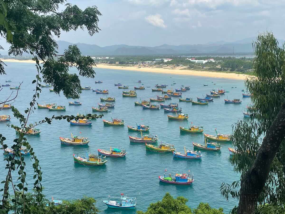 Kleurrijke vissersbootjes in een baai bij Quy Nhon